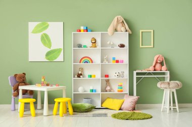 Interior of children's room with shelf unit, tables and toys