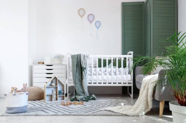Interior of nursery with crib, sofa and toys
