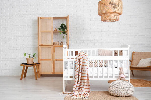 Interior of children's bedroom with crib, closet and plants