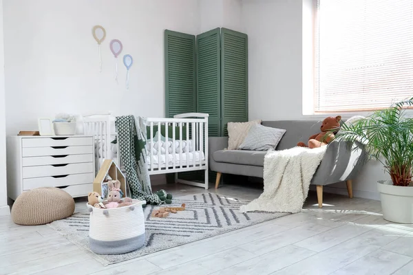 Interior of nursery with crib, sofa and toys
