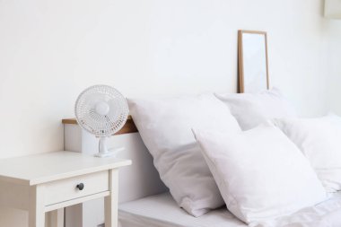 Işık odasındaki masada elektrikli vantilatör var.