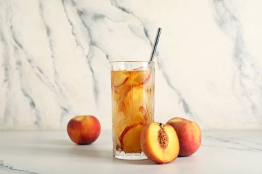 Bir bardak tatlı şeftalili buzlu çay mermer arka planda, yakın plan.