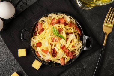 Siyah arka planda lezzetli makarna ile kızartma tavası.