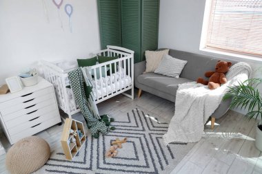 Interior of nursery with crib, sofa and toys