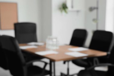 Toplantı için hazırlanan su şişeleri ve kağıt kağıtlarla dolu bulanık masa manzarası konferans salonunda.