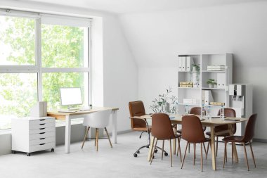 Interior of conference hall with desks, shelf unit and water cooler