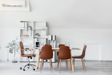 Interior of conference hall with table, shelf unit and water cooler