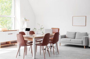 Konferans salonunun içinde masa ve kanepe var.