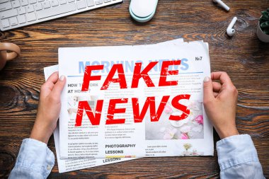 İş yerinde gazete okuyan kadın ahşap arka planda