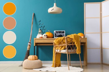 Workplace with laptop decorated for Halloween celebration in office. Different color patterns