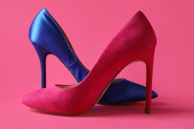 Pembe arka planda farklı yüksek topuklu ayakkabılar.