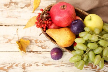 Beyaz ahşap arka planda farklı taze meyvelerle dolu sepet.