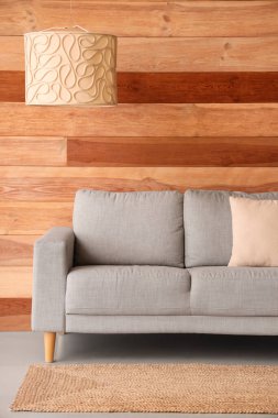 Gri kanepe ve asılı lambayla oturma odasının içinde.