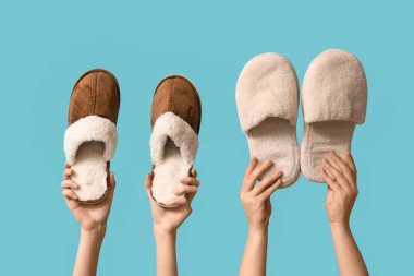 Mavi arka planda terlikleri tutan kadın elleri