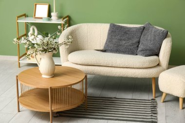 Oturma odasının iç tarafındaki masada çiçek açan bir vazo.