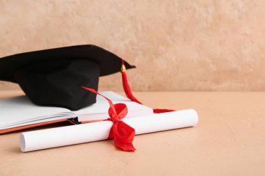 Bej arkaplan üzerine kitap ve harç tahtasıyla diploma