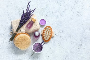 Hafif arka planda lavanta yağı şişeleri ve masaj vücut fırçaları ile güzel bir kompozisyon