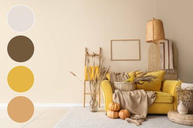 Yellow sofa, pumpkins and basket in autumn interior of living room. Different color patterns