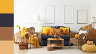 Interior of living room with autumn decor, blue sofa and wicker armchairs. Different color patterns