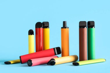 Mavi arka planda farklı elektronik sigaralar.