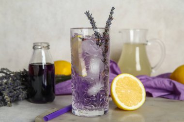 Bir bardak soğuk lavantalı limonata, limon ve şurup.