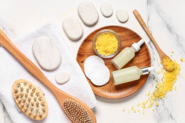 Hafif arka planda spa aksesuarları ve gerekli yağ şişeleriyle kompozisyon