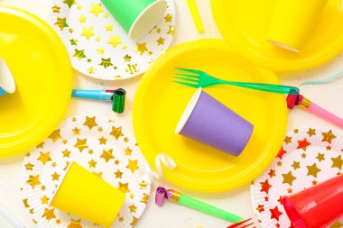 Açık arkaplanda doğum günü partisi için parlak kağıt sofra takımı ve dekor içeren kompozisyon