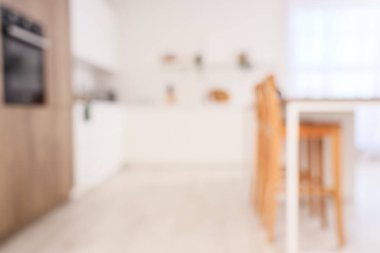 Beyaz tezgahlı ve masalı aydınlık mutfağın bulanık görüntüsü