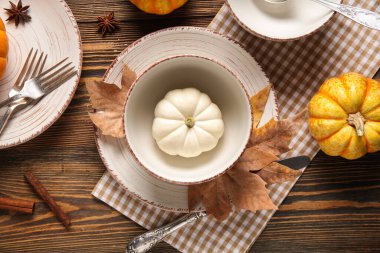 Taze balkabakları, yıldız anason, tarçın ve ahşap arka planda sonbahar yapraklarıyla güzel bir masa.