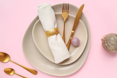 Pembe arka planda Noel topları olan güzel bir masa.