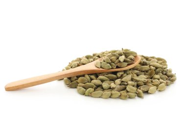 Beyaz arka planda kakule baharatlı tahta kaşık.