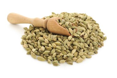 Beyaz arka planda kakule baharatlı ahşap kepçe.