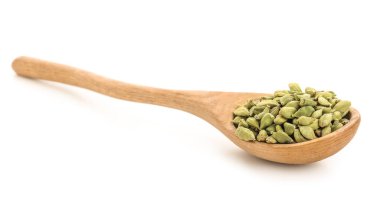 Beyaz arka planda kakule baharatlı tahta kaşık.