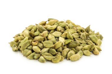 Beyaz arka planda kakule baharatı yığını