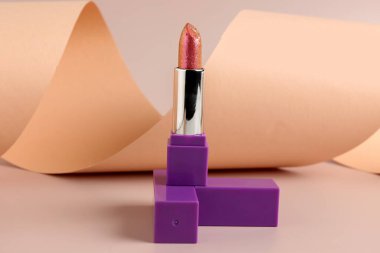 Beautiful lipstick on beige background