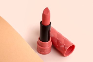 Beautiful pink lipstick on beige background