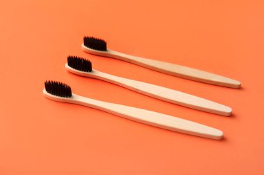 Turuncu arka planda bambu diş fırçaları, yakın plan.