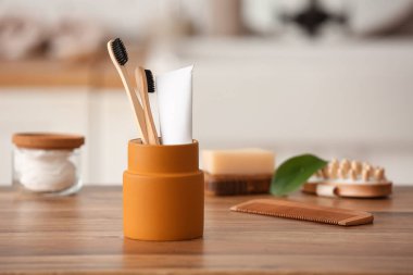 Bambu diş fırçalı tutucu, banyodaki masada tutkal ve tarak tüpü.