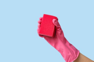 Mavi arka planı temizlemek için kauçuk eldiven tutuyordu.