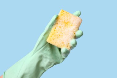 Mavi arka planı temizlemek için kauçuk eldiven tutuyordu.