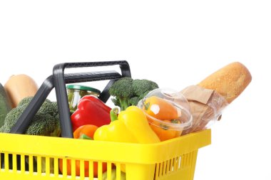 Beyaz arka planda farklı taze ürünleri olan sarı alışveriş sepeti.