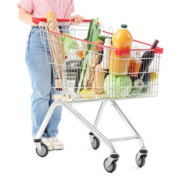 Woman with shopping cart full of different fresh products on white background