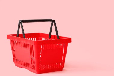 Pembe arka planda kırmızı alışveriş sepeti