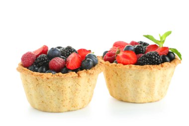 Farklı taze böğürtlenli tatlı tartlar ve beyaz arka planda nane şekeri.