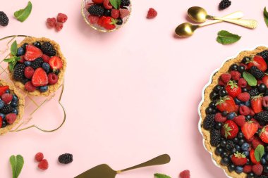 Tatlı tart ve tartlardan yapılmış çerçeve pembe arka planda farklı taze böğürtlenlerle