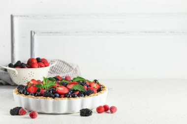 Farklı taze böğürtlenli tatlı tart ve beyaz arka planda nane.