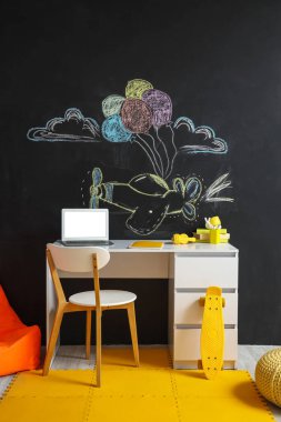 Interior of children's room with workplace and chalk wall