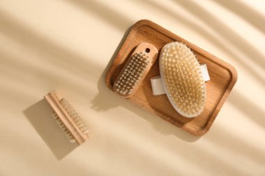 Hafif arka planda vücut masajı fırçası olan ahşap tepsi