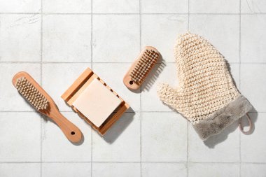 Beyaz fayanslı eldiven ve sabun çubuğu ile vücut masajı fırçaları