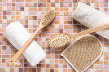 Bej fayanslı eldiven ve havlularla vücut masajı fırçaları